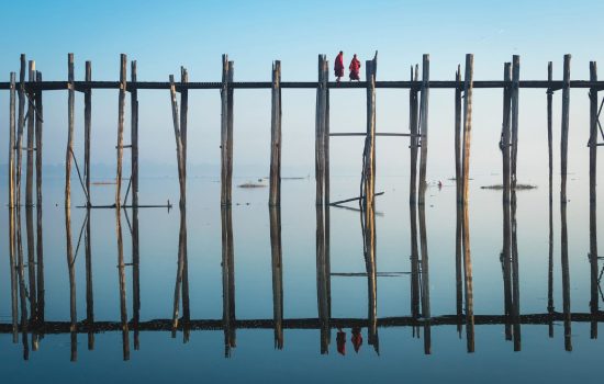 Buddhist Monks walking on U Bein Bridge early morning in Mandalay, Myanmar (Burma).